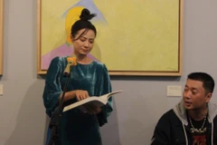Ca sỹ Giang Trang đọc ''Bến lạ'' tại khai mạc triển lãm ''Về bến lạ'' của Lê Thiết Cương. (Ảnh: Minh Anh/Vietnam+)