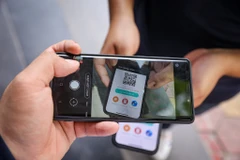 Người dân sử dụng mã QR để quét mỗi khi ra vào các cơ sở kinh doanh tại Hà Nội. (Ảnh: Minh Sơn/Vietnam+)
