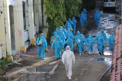 Lực lượng chức năng tỉnh Cà Mau đưa 83 ca F1 đi cách ly tập trung tại Trường Cao đẳng Cộng đồng. (Ảnh: Huỳnh Anh/TTXVN)