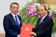 Thủ tướng Nguyễn Xuân Phúc trao quyết định của Chủ tịch nước bổ nhiệm ông Trương Quang Nghĩa giữ chức Bộ trưởng Bộ Giao thông Vận tải. (Ảnh: Thống Nhất/TTXVN)