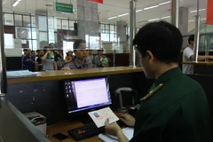 Bộ đội Biên phòng Cửa khẩu quốc tế Lào Cai làm thủ tục cho khách xuất cảnh. (Ảnh: Vũ Sinh/TTXVN)
