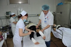 Công nhân đang được các bác sỹ ở Bệnh viện Đa khoa 115 cấp cứu. (Ảnh: Bích Huệ/TTXVN)