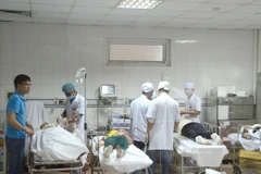 Các công nhân đang được các bác sỹ ở Bệnh viện Đa khoa 115 cấp cứu, băng bó vết thương. (Ảnh: Bích Huệ/TTXVN)