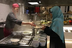 Khách Malaysia thưởng thức món Phở truyền thống Việt Nam. (Ảnh: Kim Dung/Vietnam+)