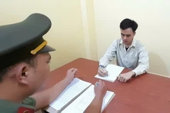 Đối tượng Trần Khắc Đức (giữa) tại cơ quan công an. (Ảnh: TTXVN phát)