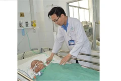 Bác sỹ thăm khám Bà mẹ Việt Nam anh hùng Đinh Thị Thà sau phẫu thuật. (Ảnh: TTXVN phát)