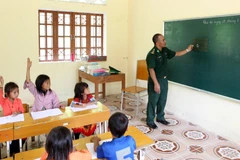 Thầy giáo quân hàm xanh thuộc đồn biên phòng A Mú Sung, huyện Bát Xát, Lào Cai dạy học cho các em học sinh tại điểm trường Phù Lao Chải. (Ảnh minh họa: Quốc Khánh/TTXVN)