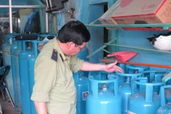 Lực lượng QLTT Hà Nội kiểm tra chất lượng vỏ bình gas tại các đại lý. (Ảnh: Đức Duy/Vietnam+)