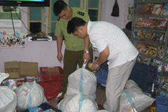 Lực lượng liên ngành 127/HBT đang tiến hành kiểm đếm đĩa lậu tại số nhà 4, ngõ 20, phố Võ Thị Sáu (Ảnh: Đức Duy/Vietnam+)