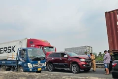 Hiện trường vụ tai nạn liên hoàn giữa 2 xe container và một ôtô 5 chỗ ngồi tại Km 26+000 thuộc xã Thạnh Đức, huyện Bến Lức, tỉnh Long An. (Ảnh: TTXVN phát)