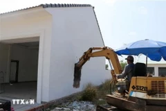 Chủ nhân căn biệt thự tự tháo dỡ công trình xây dựng vi phạm để trả lại đất cho Nhà nước. (Ảnh: Lê Huy Hải/TTXVN)