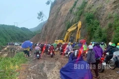 Lực lượng chức năng huy động phương tiện khắc phục sạt lở, hỗ trợ người dân lưu thông qua dốc Cun, tỉnh Hòa Bình. (Nguồn: báo Hòa Bình)