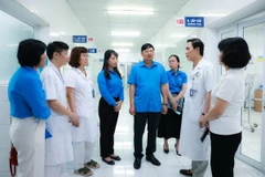 Đại diện Tổng Liên đoàn Lao động Việt Nam cùng Liên đoàn Lao động thành phố Hà Nội đến thăm, động viên và trao hỗ trợ cho các nạn nhân trong vụ cháy. (Ảnh: TTXVN phát)