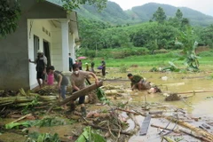 Người dân địa phương nỗ lực tìm người thân bị nạn sau lũ dữ. (Ảnh: Hồng Ninh/TTXVN)