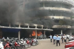 Xe cấp cứu đậu trong bãi xe cháy nghi ngút. (Nguồn: Báo Công an Nhân dân)