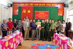 Thượng tá Phạm Văn Tám, Phó Tham mưu trưởng Bộ đội Biên phòng tỉnh Bà Rịa-Vũng Tàu tặng hoa và chụp ảnh lưu niệm cùng các thuyền viên và đại diện Tổng Lãnh sự quán hai nước. (Ảnh: TTXVN phát)