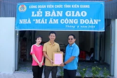 Ông Nguyễn Quốc Hùng, Chủ tịch Công đoàn Viên chức tỉnh Kiên Giang, trao quyết định bàn giao “Mái ấm Công đoàn” cho đoàn viên. (Ảnh: Lê Huy Hải/TTXVN)