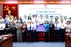 Phó Chủ tịch, Tổng Thư ký Ủy ban Trung ương MTTQ Việt Nam Nguyễn Thị Thu Hà tiếp nhận bảng tượng trưng số tiền ủng hộ từ Phó Thống đốc Ngân hàng Nhà nước Việt Nam Đào Minh Tú. (Ảnh: Minh Đức/TTXVN)