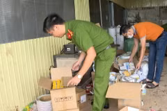 Công an kiểm tra kho chứa các vật dụng, máy móc làm giả tem nhãn của nhóm đối tượng. (Ảnh: TTXVN phát)