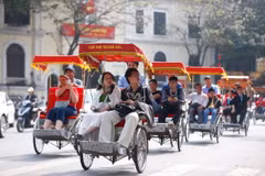 Du khách quốc tế trải nghiệm du lịch bằng xích lô quanh hồ Hoàn Kiếm, Hà Nội. (Ảnh: Minh Quyết/TTXVN)