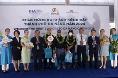 Tặng hoa, quà chúc mừng các du khách đầu tiên đến Đà Nẵng trong dịp Tết Dương lịch 2024 tại Sân bay Quốc tế Đà Nẵng. (Ảnh: Trần Lê Lâm/TTXVN)