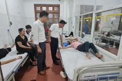 Giám đốc Sở Y tế tỉnh Vĩnh Phúc Lê Hồng Trung thăm hỏi, kiểm tra sức khỏe công nhân bị ngộ độc thực phẩm đang được điều trị tại Trung tâm y tế thành phố Vĩnh Yên. (Ảnh: Nguyễn Thảo/TTXVN)