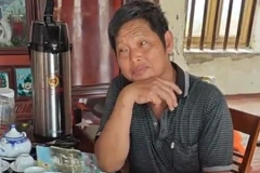 Đối tượng Tiệp bị bắt quả tang nhận 500 triệu đồng. (Ảnh TTXVN phát)