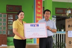 Phó Tổng giám đốc TTXVN Nguyễn Tuấn Hùng trao tặng số tiền 100 triệu đồng của TTXVN hỗ trợ Trường Mầm non Hoa Lan, phường Hồng Hà, thành phố Yên Bái khắc phục thiệt hại của bão số 3. (Ảnh: Tiến Khánh/TTXVN)