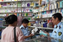 Cán bộ Quản lý thị trường kiểm tra tại cửa hàng mỹ phẩm. (Ảnh: Văn Sĩ/TTXVN)