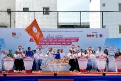 Phó Bí thư Thành đoàn Thành phố Hồ Chí Minh Trịnh Thị Hiền Trân trao cờ ra quân “Tiếp sức người lao động và Ngày hội tuyển dụng việc làm” năm 2024. (Ảnh: Thanh Vũ/TTXVN)