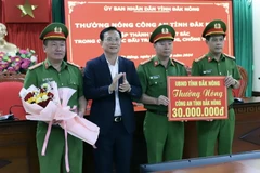 Ông Hồ Văn Mười, Chủ tịch UBND tỉnh Đắk Nông thưởng nóng Công an tỉnh Đắk Nông về thành tích phá nhanh vụ án. (Ảnh: TTXVN phát)