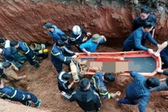Lực lượng chức năng triển khai công tác cứu nạn cứu hộ đưa nạn nhân lên mặt đất. (Ảnh TTXVN phát)