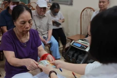 Chi trả cho người nhận lương hưu, trợ cấp BHXH tại điểm Nhà văn hóa khu dân cư số 3A-3B Thanh Lương, quận Hai Bà Trưng, Hà Nội. (Ảnh: Hoàng Hiếu/TTXVN)