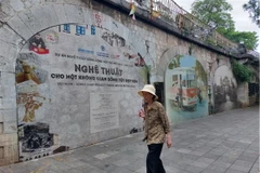 Hoạt động sáng tạo biến các vòm cầu đường sắt Phùng Hưng thành phố bích họa. (Ảnh: Đinh Thuận/TTXVN)