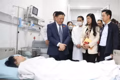 Bí thư Thành ủy Hà Nội Đinh Tiến Dũng thăm nạn vụ cháy. (Ảnh: TTXVN phát)