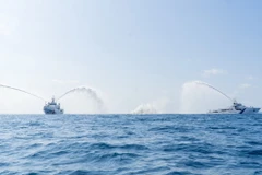 Tàu CSB 8005 thuộc Bộ Tư lệnh Vùng Cảnh sát biển 3 và tàu Sumadra Paheredar-ICG 202 của Lực lượng Bảo vệ bờ biển Ấn Độ tiến hành hiệp đồng phun vòi rồng dập tắt đám cháy trên biển. (Ảnh: Huỳnh Sơn/TXVN)