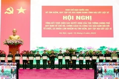 Thượng tướng Võ Minh Lương trao Bằng khen tặng các tập thể có thành tích xuất sắc trong chỉ đạo, triển khai thực hiện các chế độ, chính sách và công tác bảo đảm làm nhiệm vụ tìm kiếm quy tập hài cốt liệt sỹ. (Ảnh: Hồng Pha/TTXVN phát)