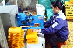 Người dân dùng máy cắt bánh tráng Tân An để đóng gói sản phẩm. (Ảnh: Tá Chuyên/TTXVN)