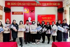 Đại diện giáo viên nhà trường tiếp nhận quà của em Phú. (Ảnh: TTXVN phát)