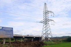 Trụ điện 22kV chưa được di dời nằm sát vị trí đường công vụ và thi công cầu dự án thành phần cao tốc Chí Thạnh-Vân Phong. (Ảnh: Xuân Triệu/TTXVN)
