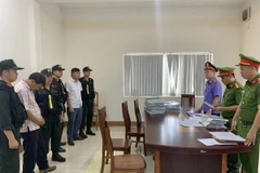 Đọc lệnh bắt đối tượng Vương Viết Thắng và Dương Phúc Hiếu, cán bộ Phòng Tài nguyên Môi trường huyện Hướng Hóa. (Ảnh: TTXVN phát)