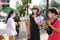 Chủ quán bún ngan trao tặng quà cho người khó khăn (Ảnh: Hoàng Đạt/Vietnam+)