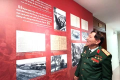 Trung tướng Phạm Tuân nhìn lại hình ảnh của chính mình trong trân chiến 50 năm trước. (Ảnh: Minh Thu/Vietnam+)