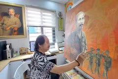 Họa sỹ Trần Xuân Phúc bên tác phẩm khắc họa Chủ tịch Hồ Chí Minh với lực lượng vũ trang. (Ảnh: Minh Thu/Vietnam+)