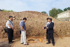 Phó giáo sư-tiến sỹ Tống Trung Tín, Chủ tịch Hội Khảo cổ học Việt Nam (bìa phải) cùng các chuyên gia bên một miệng giếng. (Ảnh: Minh Thu/Vietnam+)