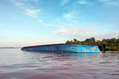 Một phương tiện bị lật úp trên sông Soài Rạp. (Ảnh: TTXVN phát)