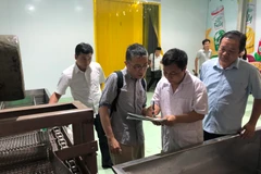 Chuyên gia Nhật Bản kiểm tra các thiết bị trước khi đưa vải vào xử lý. (Ảnh: Lâm Phan/Vietnam+)