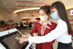 Khách hàng sử dụng Smart Kiosk tại HDBank. (Ảnh: Vietnam+)