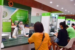 Giao dịch tại Vietcombank. (Ảnh: Vietnam+)