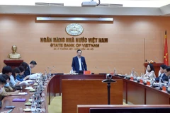 Phó Thống đốc Đào Minh Tú chủ trì hội nghị trực tuyến. (Ảnh: CTV/Vietnam+)
